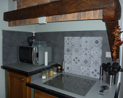 Fond de hotte en aluminium avec motifs carreaux de ciment imprimé avec effet relief. Ce fond de hotte est installé dans une cuisine à Saint Jean le Centenier Ardèche 07.